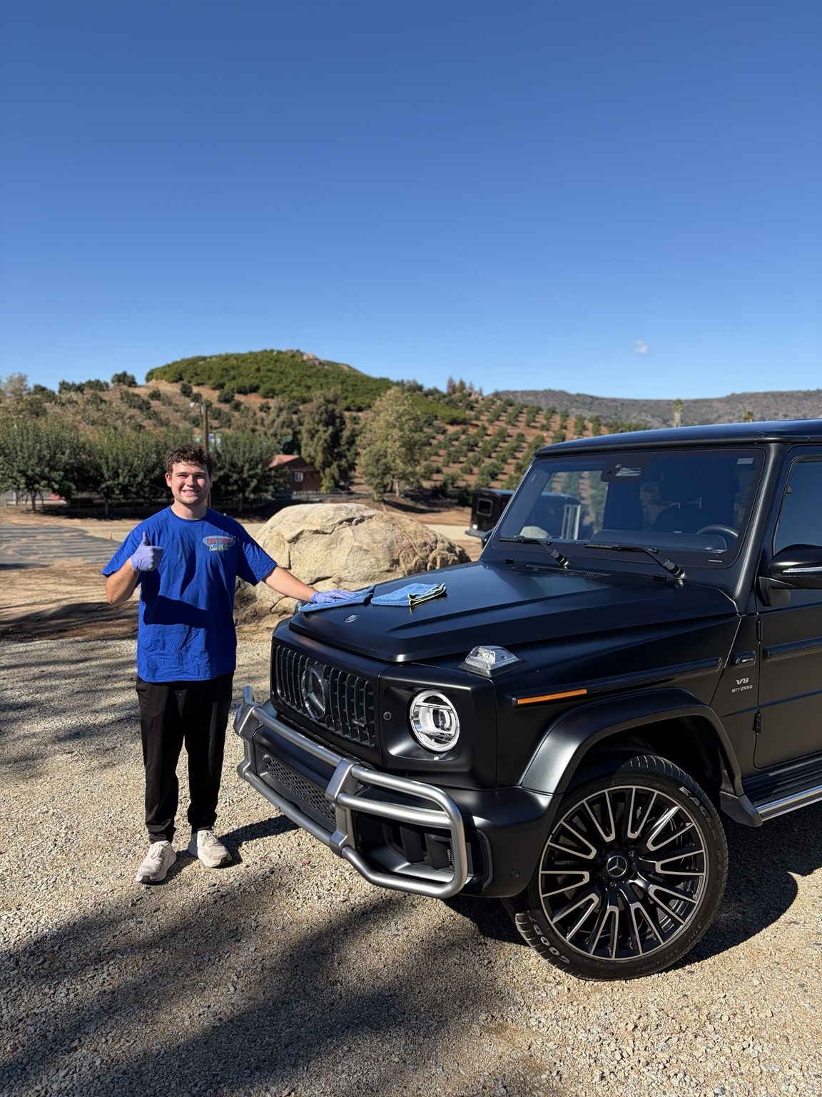 Easy Peasy team member beside a freshly cleaned Mercedes G-Class