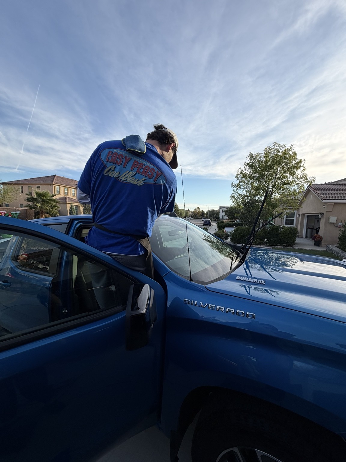 Easy Peasy team member cleaning a blue Chevrolet Silverado